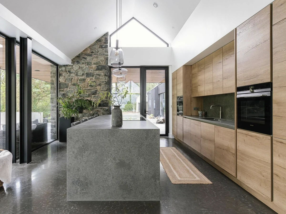 Renovated kitchen with oak cabinetry and a stone waterfall island